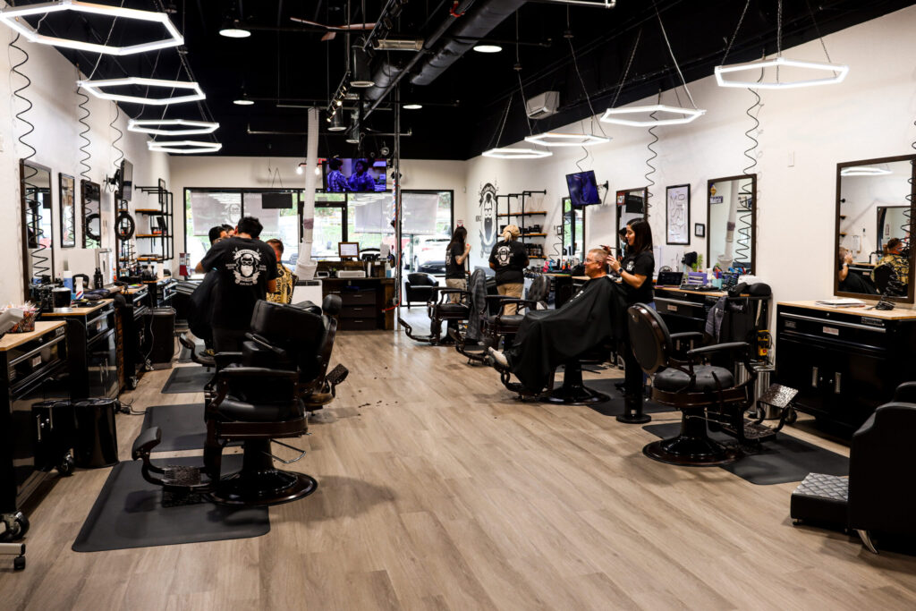 Barbers cutting a client’s hair.